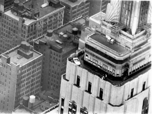 The white 1965 Ford Mustang convertible on the observation deck of the 86th floor of the Empire State Building at dawn